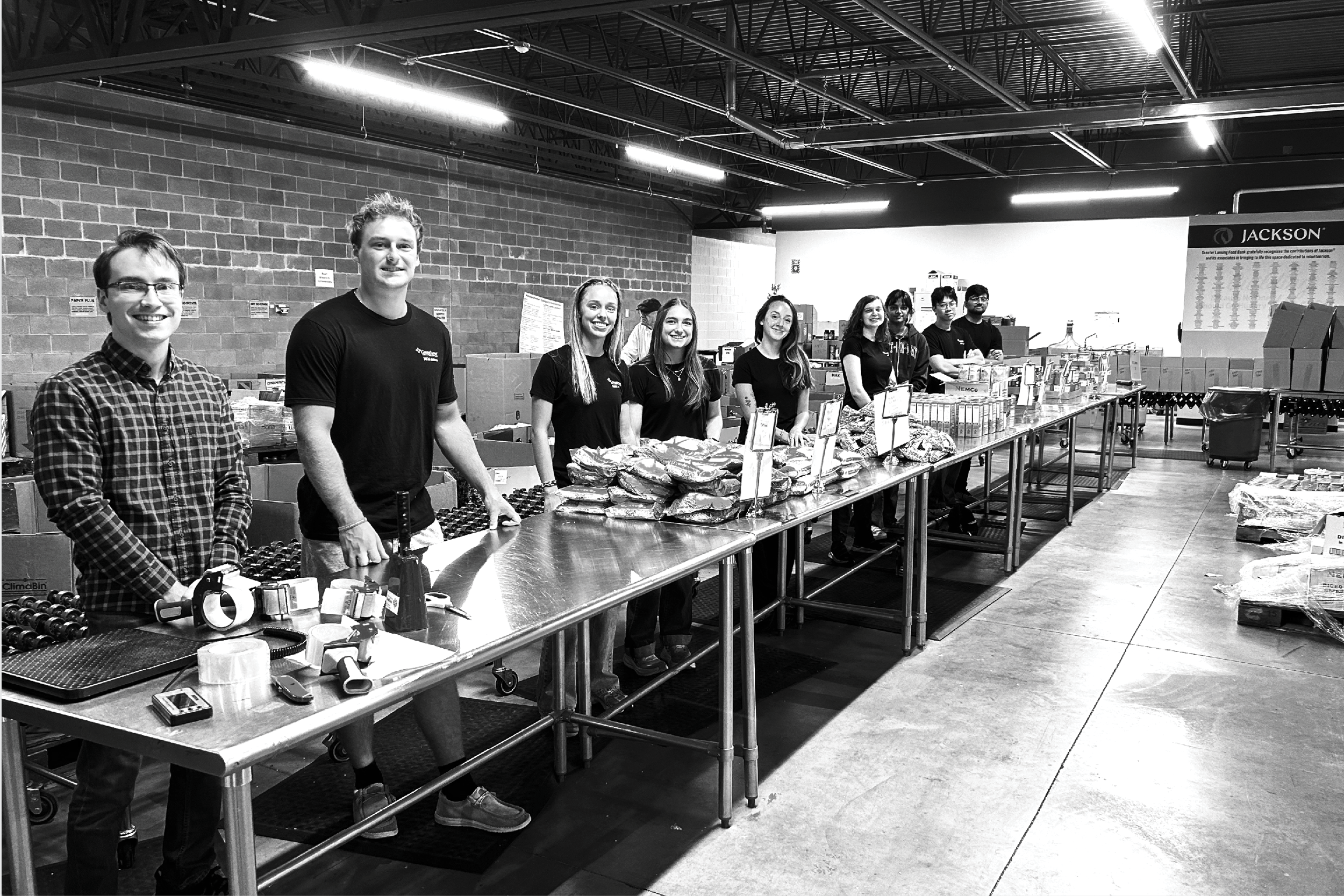 Students standing at a table smiling