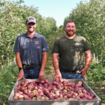 Two men farmers standing apple fields